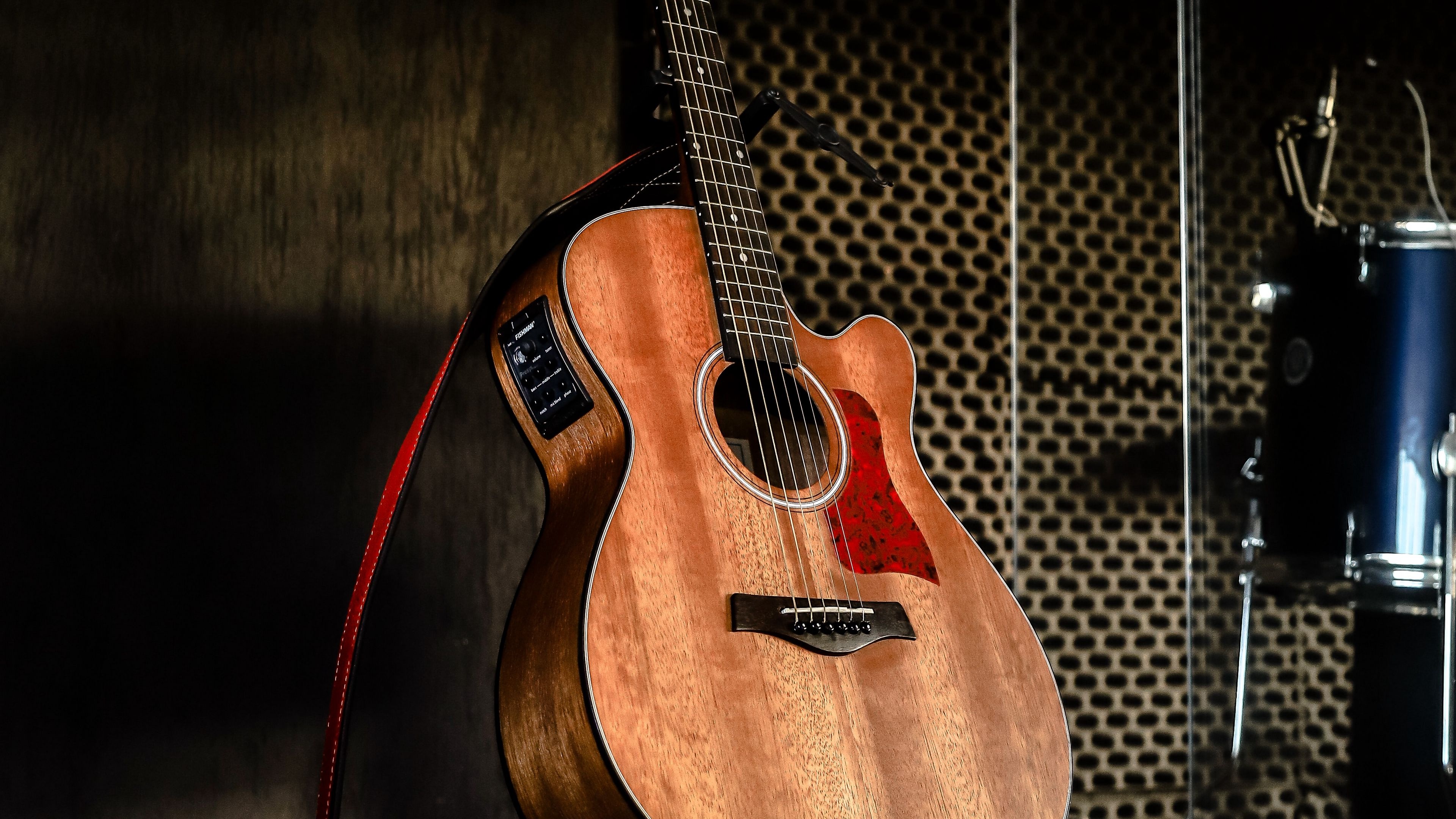Acoustic guitar fretboard illuminated by warm golden studio lighting